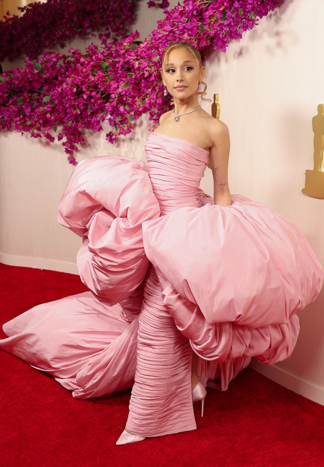 Ariana Grande nodded to her role as the good witch in the forthcoming movie “Wicked” with her pink Giambattista Valli Haute Couture gown that featured pillowy waist attachments and a trailing train.