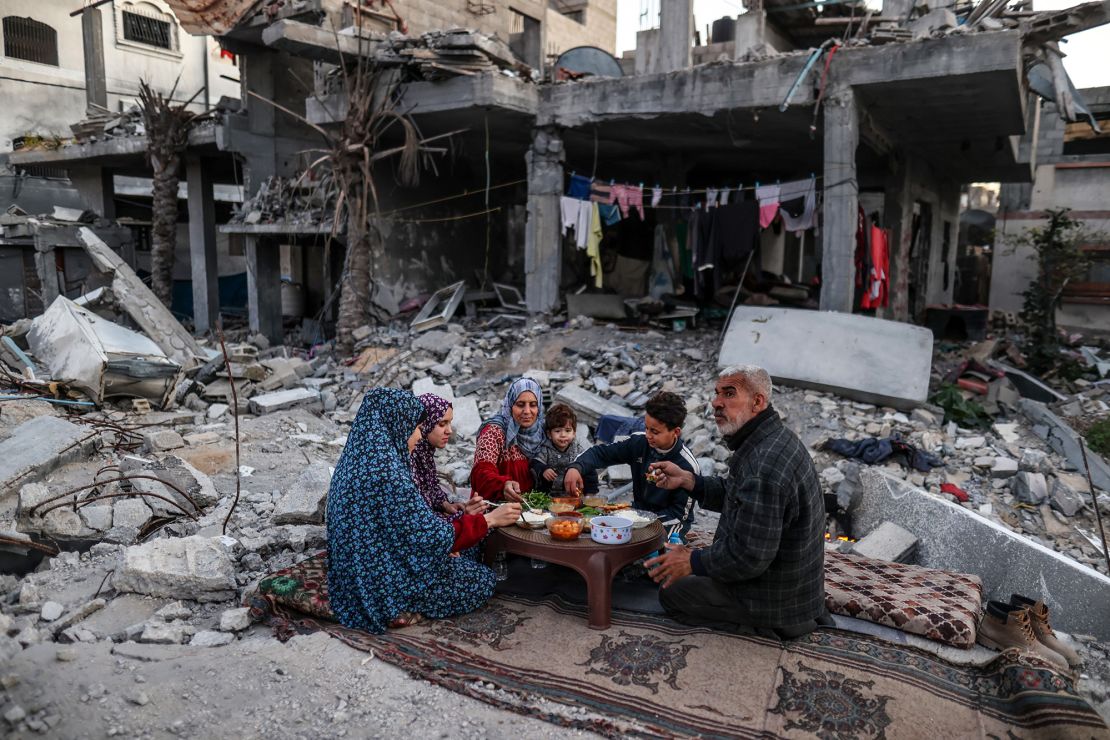 A Palestinian family break their fast among the rubble of their house, which was destroyed by Israeli bombardment, on the first day of Ramadan in Deir al-Balah, in northern Gaza, on March 11.