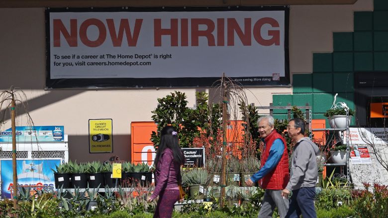 Home Depot customers walk by a posted now hiring sign on March 08, 2024, in San Rafael, California.