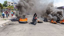 PORT-AU-PRINCE, HAITI- MARCH 12: 
A motorcyclist passes burning tires during a demonstration against CARICOM for the decision following the resignation of Haitian Prime Minister Ariel Henry as representatives of the Caribbean Community (CARICOM) and Haitian actors made an agreement for political transition in Haiti it a historic decision that was made by the formation of a seven-member Presidential Council (CP), and the Haitian government on Tuesday extended the night-time curfew and state of emergency in the capital of Port-au-Prince for a month amid a wave of violence triggered by armed groups in Port-au-Prince, Haiti, on March 12, 2024. (Photo by Guerinault Louis/Anadolu via Getty Images)