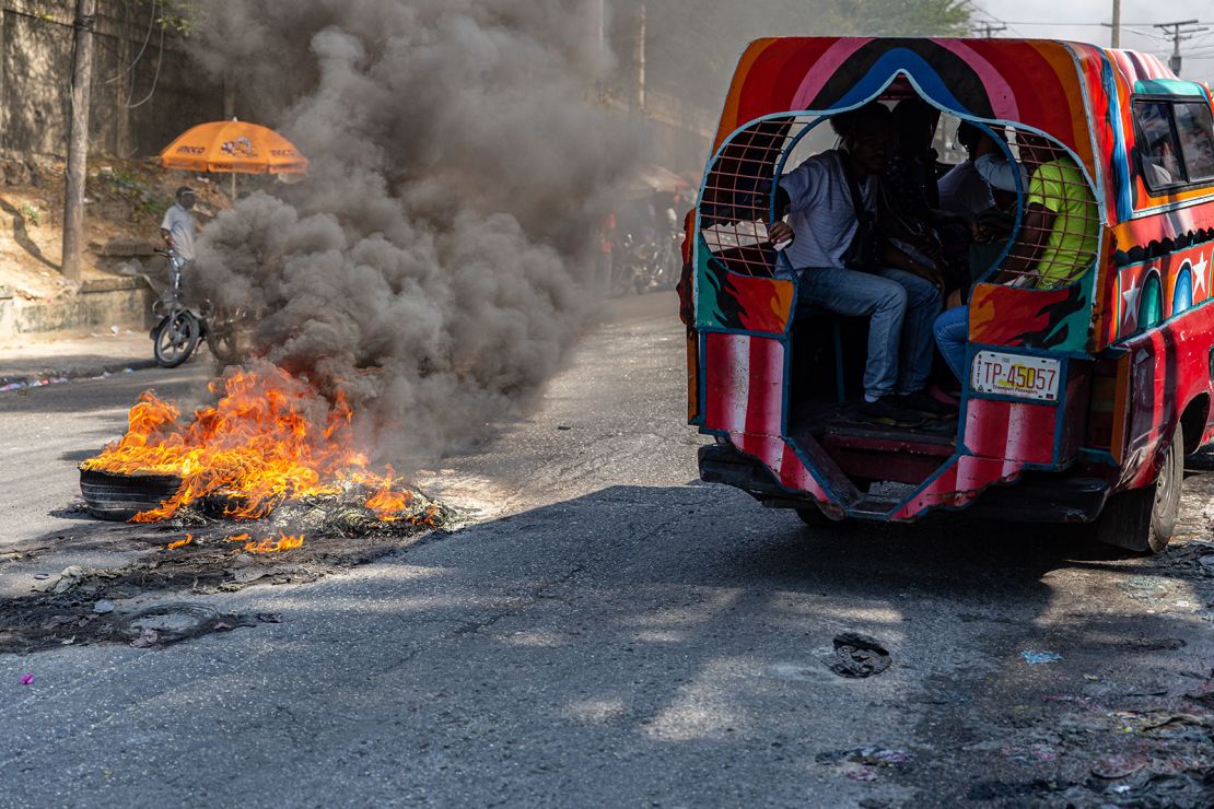 A public van passes burning tires left on a road Tuesday during a demonstration in the Haitian capital of Port-au-Prince.