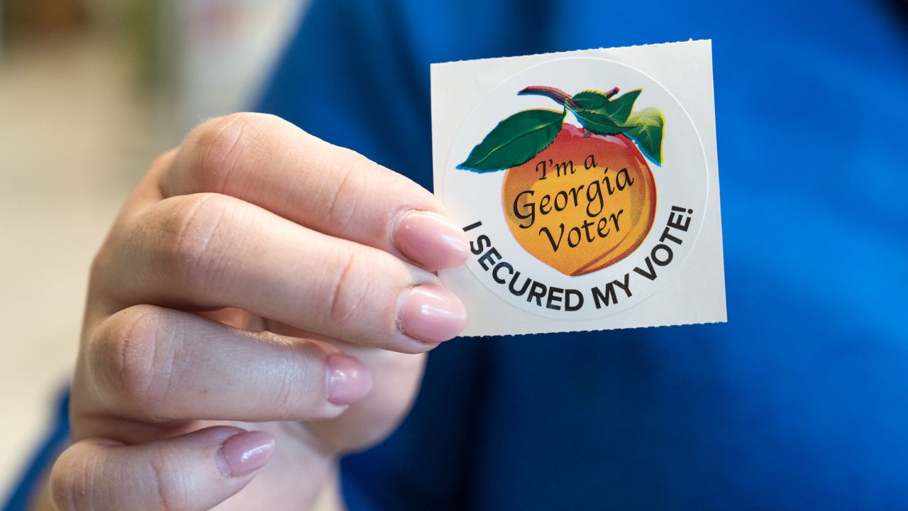 A voter holds up her sticker after casting her ballot for the Primary election on March 12, 2024 in Atlanta, Georgia.