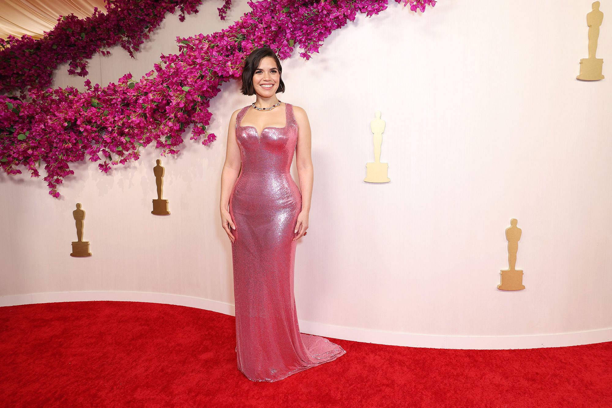 "Barbie" actor America Ferrera arrives at the 96th Academy Awards wearing a pink custom Atelier Versace pink gown and bold Pomellato jewelry.