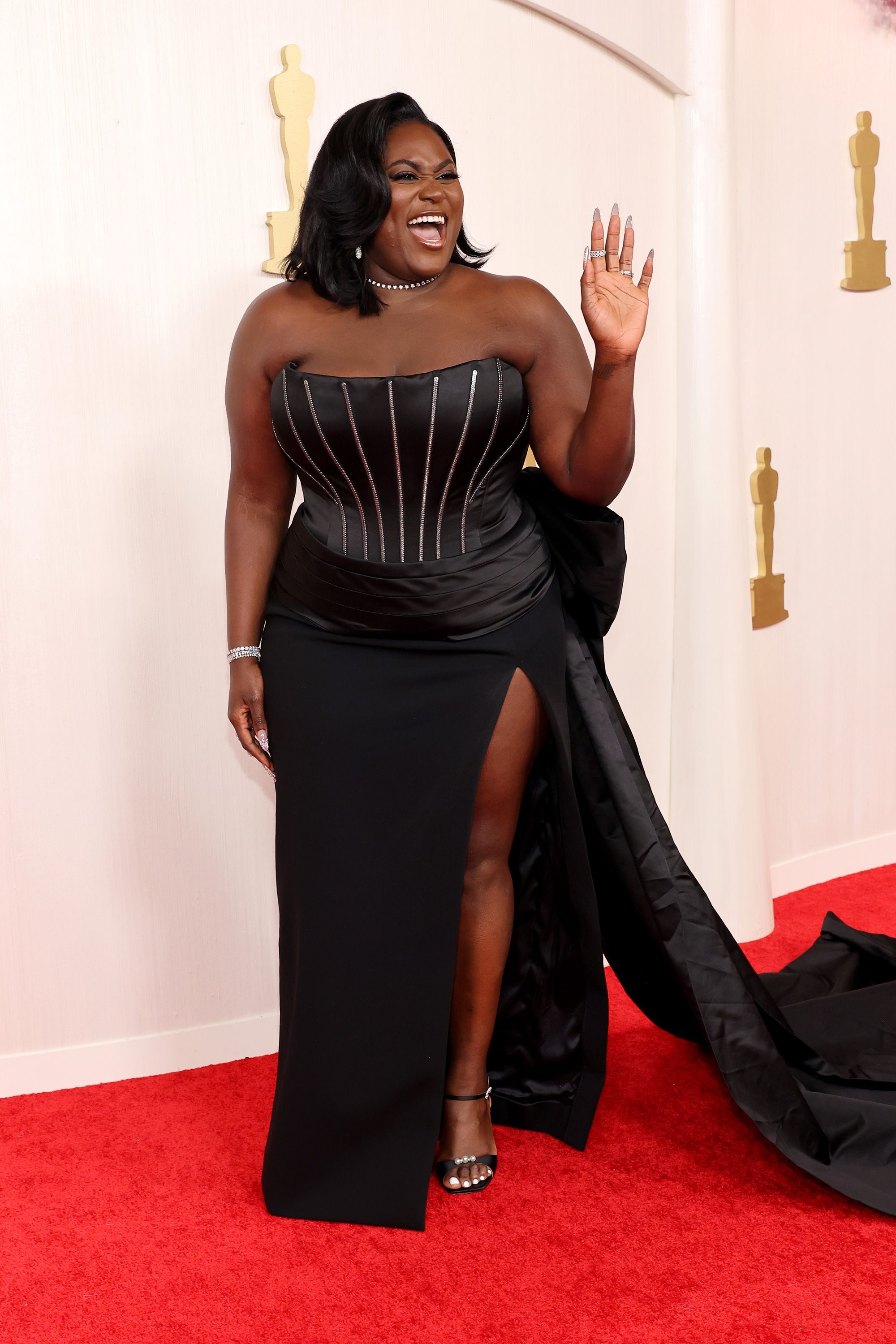 Danielle Brooks arrived in a bedazzled satin dress with exposed metal boning detailing, by Dolce & Gabbana.