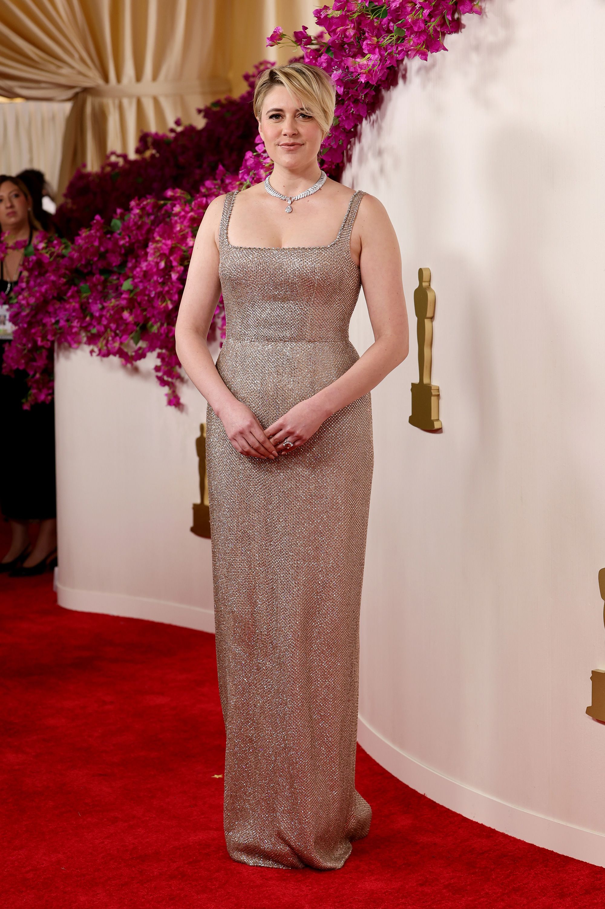 Director of the Oscar-nominated “Barbie,” Greta Gerwig, dazzled in a champagne-colored Gucci gown and a diamond-encrusted Boucheron necklace.