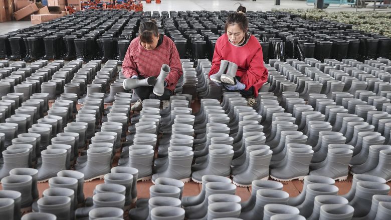 Employees check rain boots for export at a shoe factory in Lianyungang, in eastern China's Jiangsu province on March 13, 2024.
