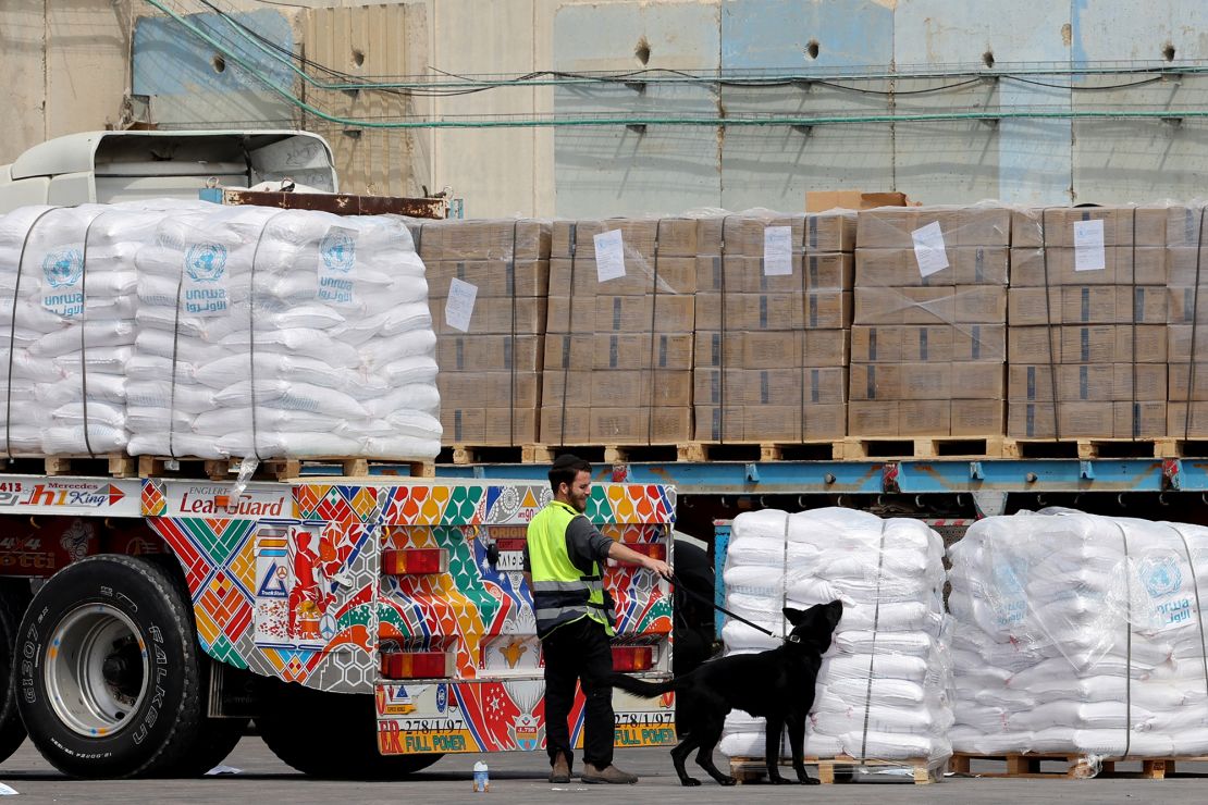 Aid shipments slated for Gaza are sniffed by a dog at the Kerem Shalom border crossing on March 14, 2024.
