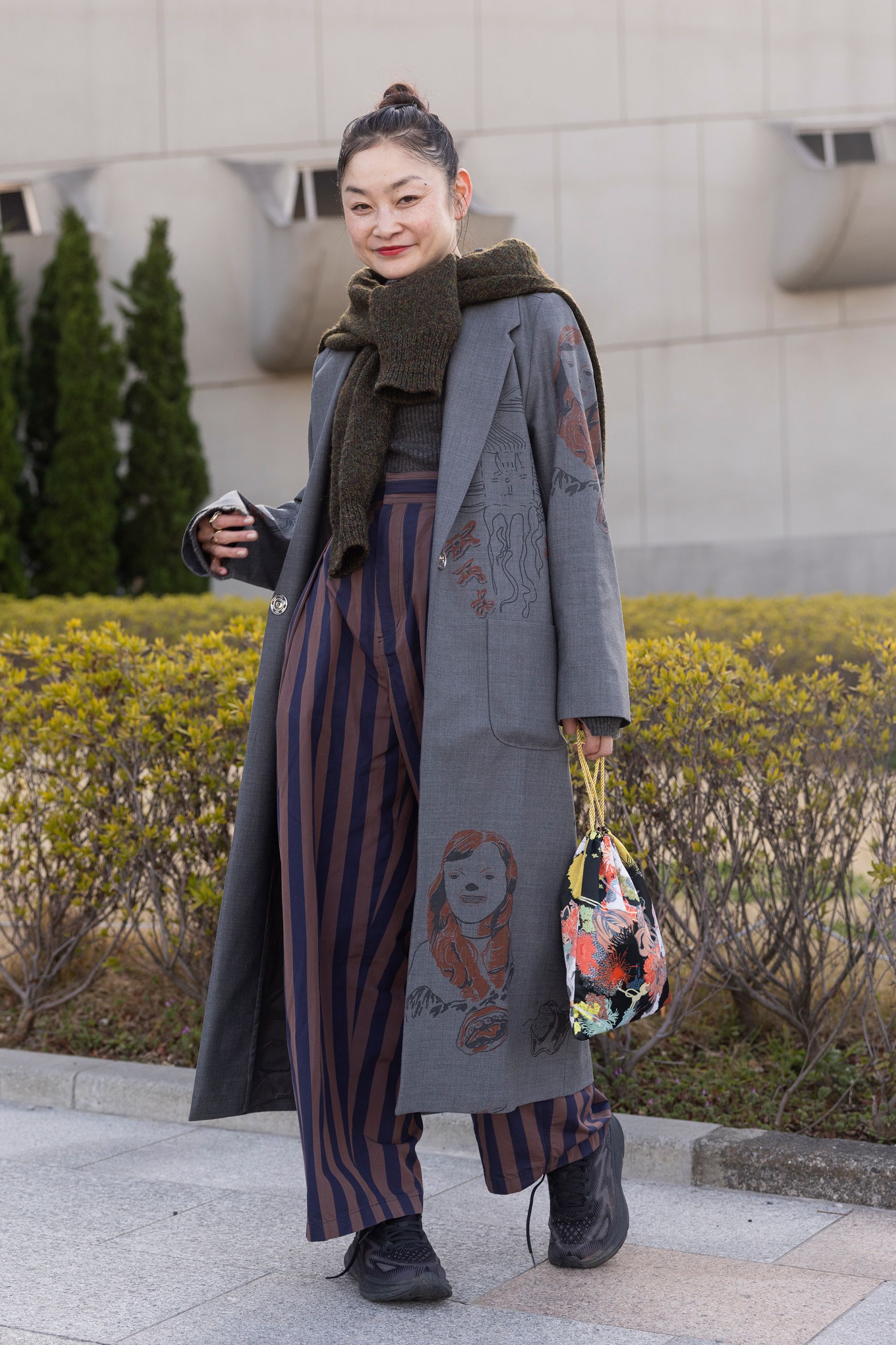 Fsahion Week attendee Reishito seen wearing a blue wool coat and stripped pants with a scarf and floral bag.