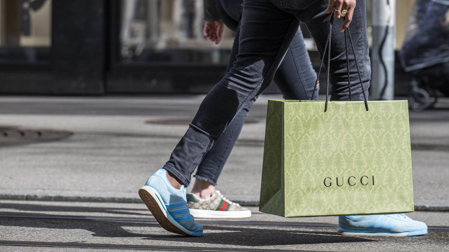 A shopper carries a Gucci shopping bag in central Zurich, Switzerland, on Saturday, March 16, 2024.