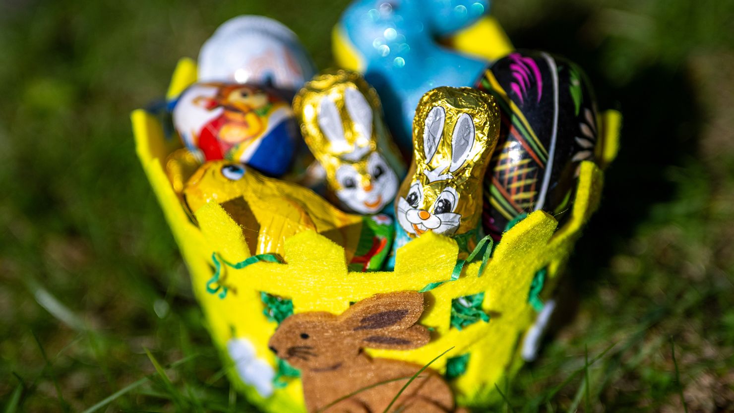 An Easter basket filled with chocolate figures and decorative eggs stands in a garden in sunny weather on March 18, 2024, in Berlin, Germany.