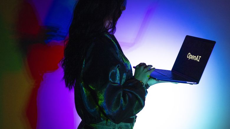 In this photo illustration, a woman looks at a laptop screen displaying the logo of 'OpenAI' in Ankara, Turkiye on March 11, 2024.