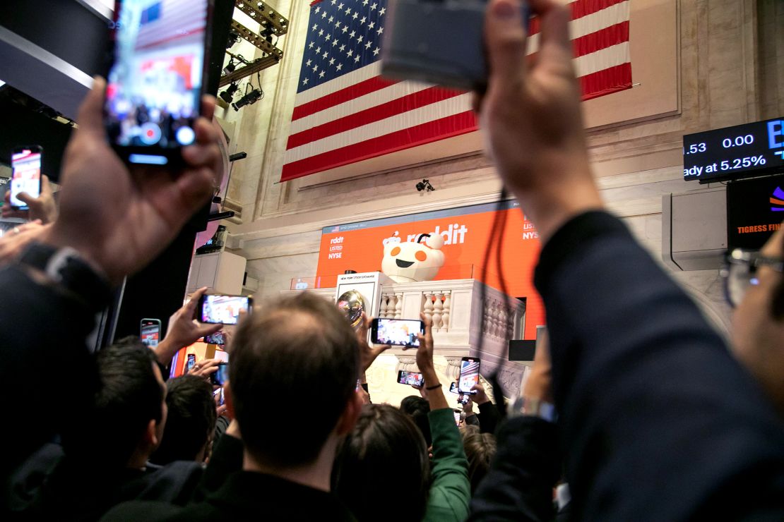Snoo, mascot of Reddit Inc., rings the opening bell during the company's initial public offering (IPO) on the floor of the New York Stock Exchange on Thursday, March 21, 2024. Reddit Inc. and its selling shareholders raised $748 million, pricing shares in an initial public offering at the top of a marketed range, the second big tech listing in as many days.