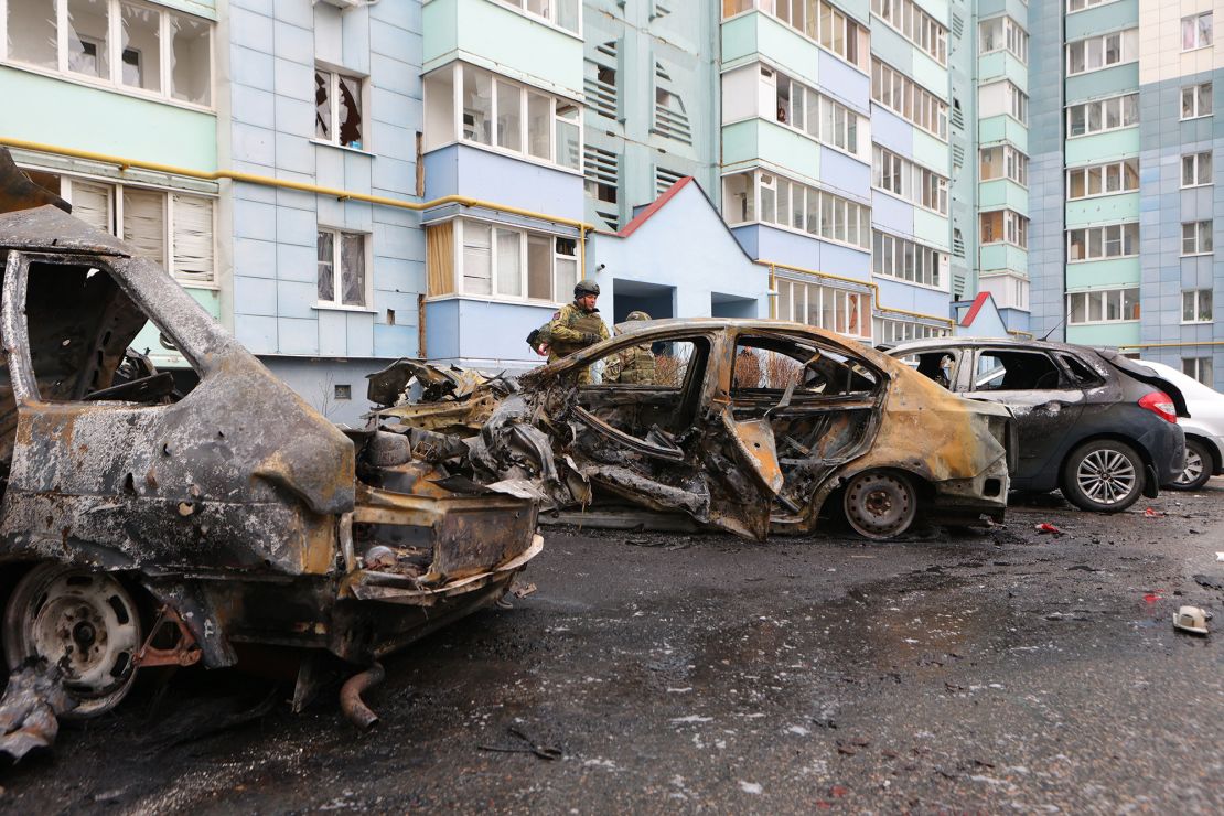 Self-defense unit volunteers stand by burned-out cars in a residential area of the city of Belgorod, Russia, following fresh aerial attacks on March 22, 2024.