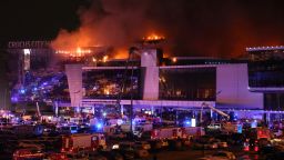 Emergency services vehicles are seen outside the burning Crocus City Hall concert hall following the terrorist attack on March 22, 2024.