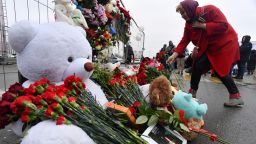 A woman lays flowers at a makeshift memorial in front of the Crocus City Hall, a day after a gun attack in Krasnogorsk, outside Moscow, on March 23, 2024. Camouflaged assailants opened fire at the packed Crocus City Hall in Moscow's northern suburb of Krasnogorsk on March 22, 2024, evening ahead of a concert by Soviet-era rock band Piknik in the deadliest attack in Russia for at least a decade. Russia on March 23, 2024, said it had arrested 11 people -- including four gunmen -- over the attack on a Moscow concert hall claimed by Islamic State, as the death toll rose to over 100 people. (Photo by Olga MALTSEVA / AFP) (Photo by OLGA MALTSEVA/AFP via Getty Images)