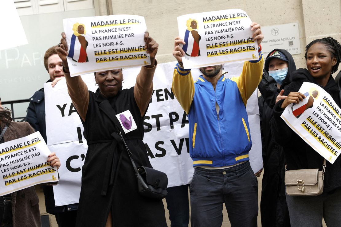 Demonstrators hold placards reading "Madame le Pen, France is not being humiliated by Blacks, it is being humiliated by racists" during a rally in front of the Rassemblement National (RN) headquarters, organised by the French association SOS Racisme in Paris on March 24, 2024, in support of Aya Nakamura.