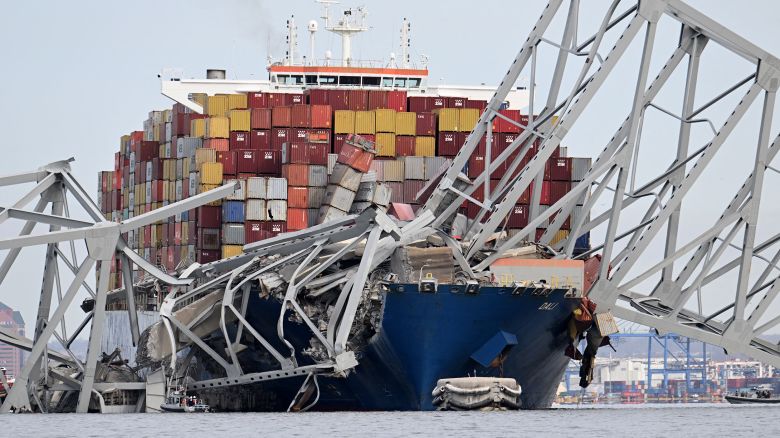 TOPSHOT - The steel frame of the Francis Scott Key Bridge sits on top of the container ship Dali after the bridge collapsed, Baltimore, Maryland, on March 26, 2024. The bridge collapsed early March 26 after being struck by the Singapore-flagged Dali, sending multiple vehicles and people plunging into the frigid harbor below. There was no immediate confirmation of the cause of the disaster, but Baltimore's Police Commissioner Richard Worley said there was "no indication" of terrorism. (Photo by Jim WATSON / AFP) (Photo by JIM WATSON/AFP via Getty Images)