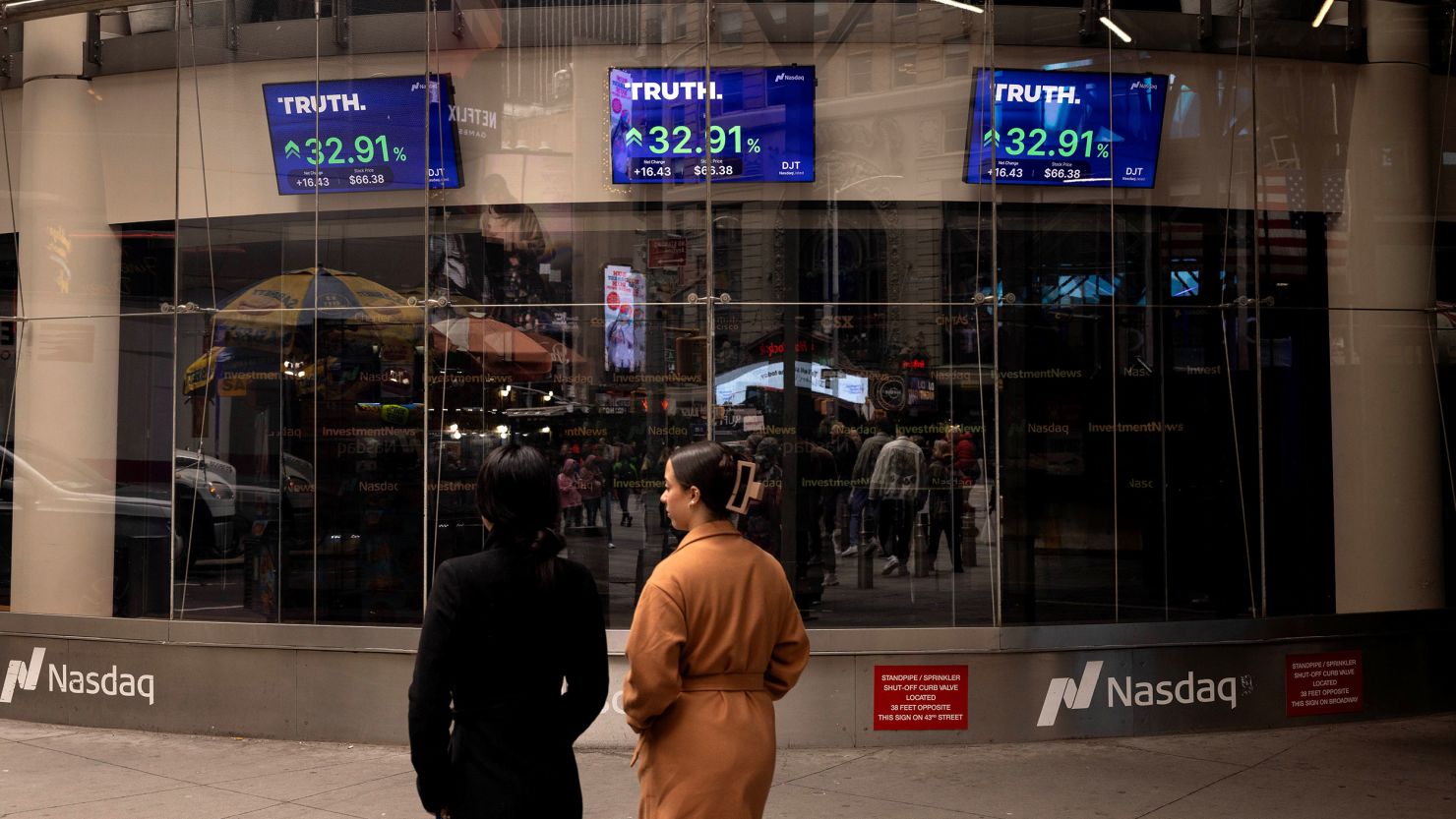Screens displaying Truth Social stock information outside the Nasdaq MarketSite in New York.