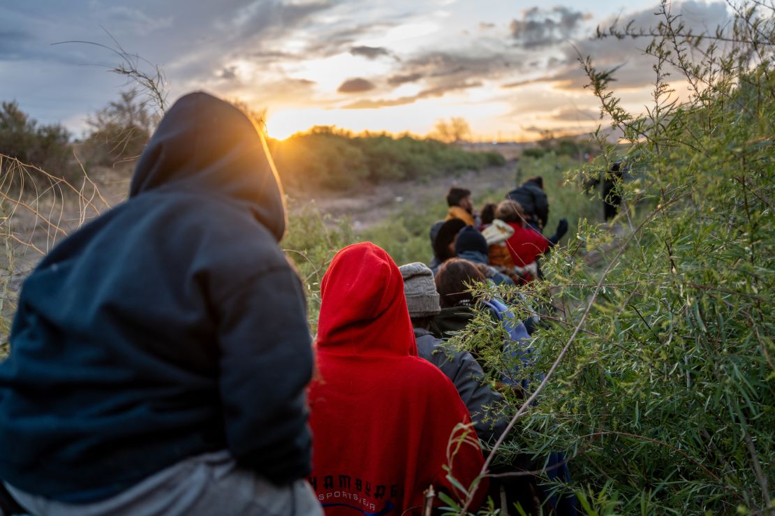 Migrants from Peru and Venezuela walk along a trail on the US side of the Rio Grande river on March 26, 2024, in El Paso, Texas.