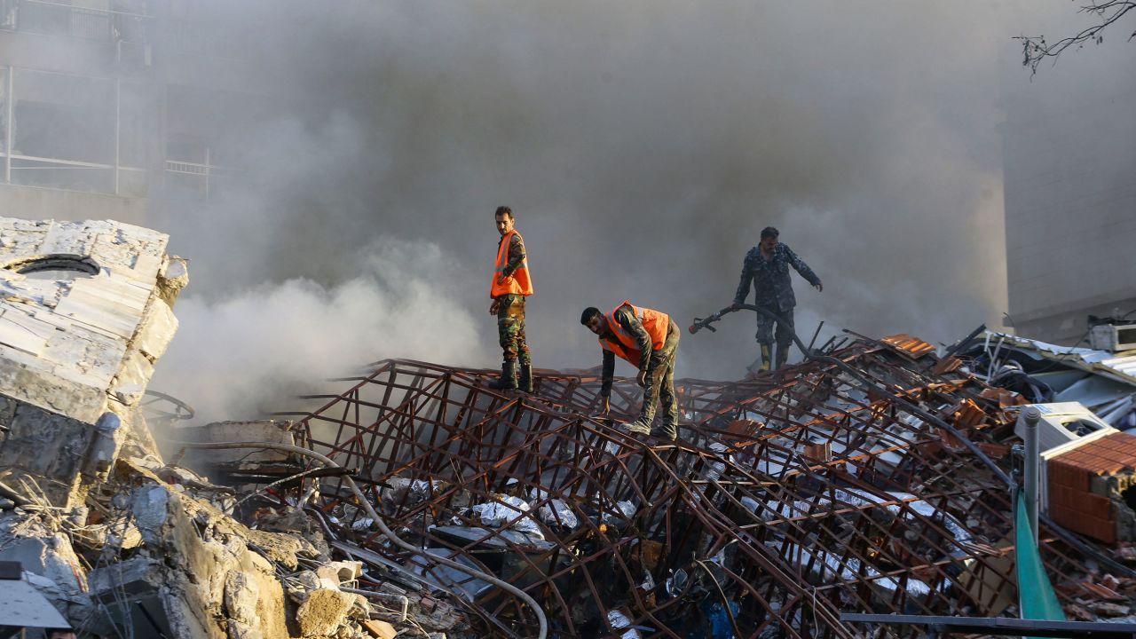 TOPSHOT - Emergency personnel extinguish a fire at the site of strikes which hit a building next to the Iranian embassy in Syria's capital Damascus, on April 1, 2024. Syrian state media said Israeli strikes hit an Iranian consular annex in the capital on April 1, while a war monitor reported eight people were killed and Iranian state media said a senior commander of the powerful Islamic Revolutionary Guard Corps was among the dead, amid rising regional tensions due to the Gaza war. (Photo by LOUAI BESHARA / AFP) (Photo by LOUAI BESHARA/AFP via Getty Images)