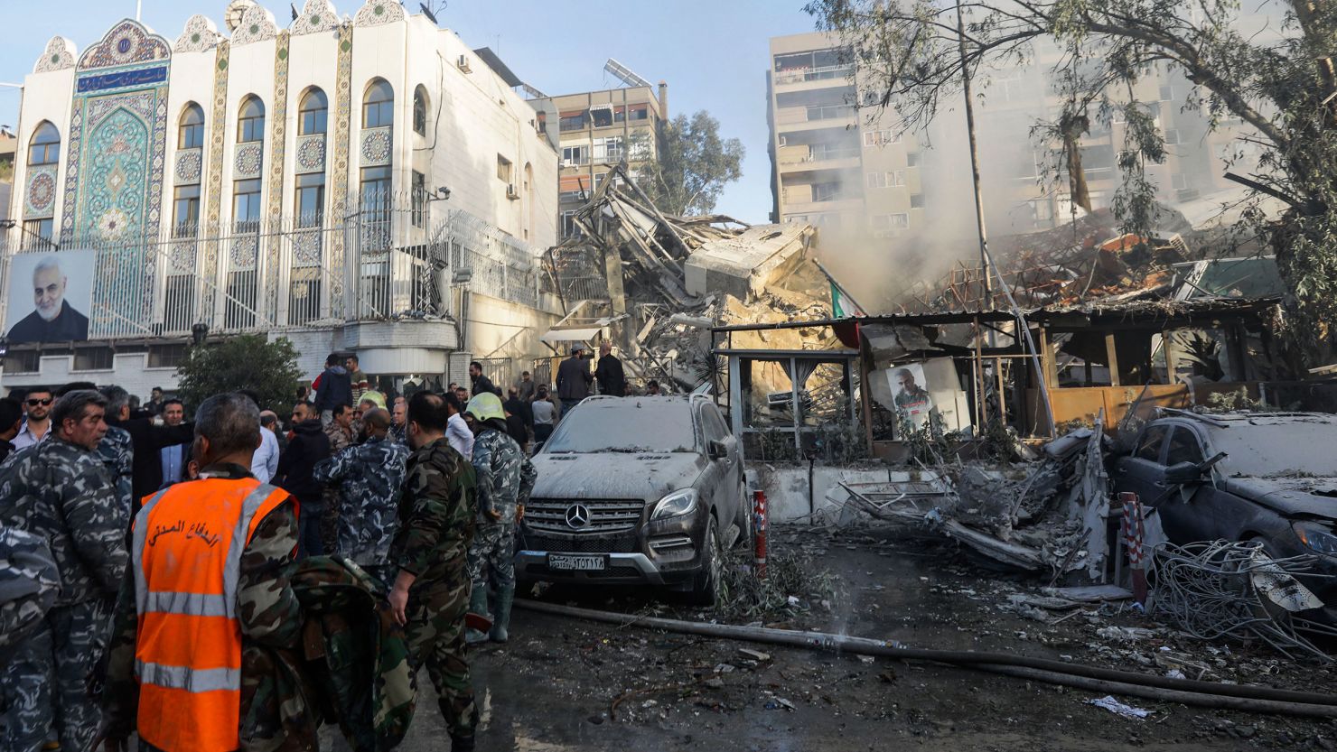 Emergency and security personnel inspect the site of strikes which hit a building next to the Iranian embassy in Syria's capital Damascus, on April 1, 2024.