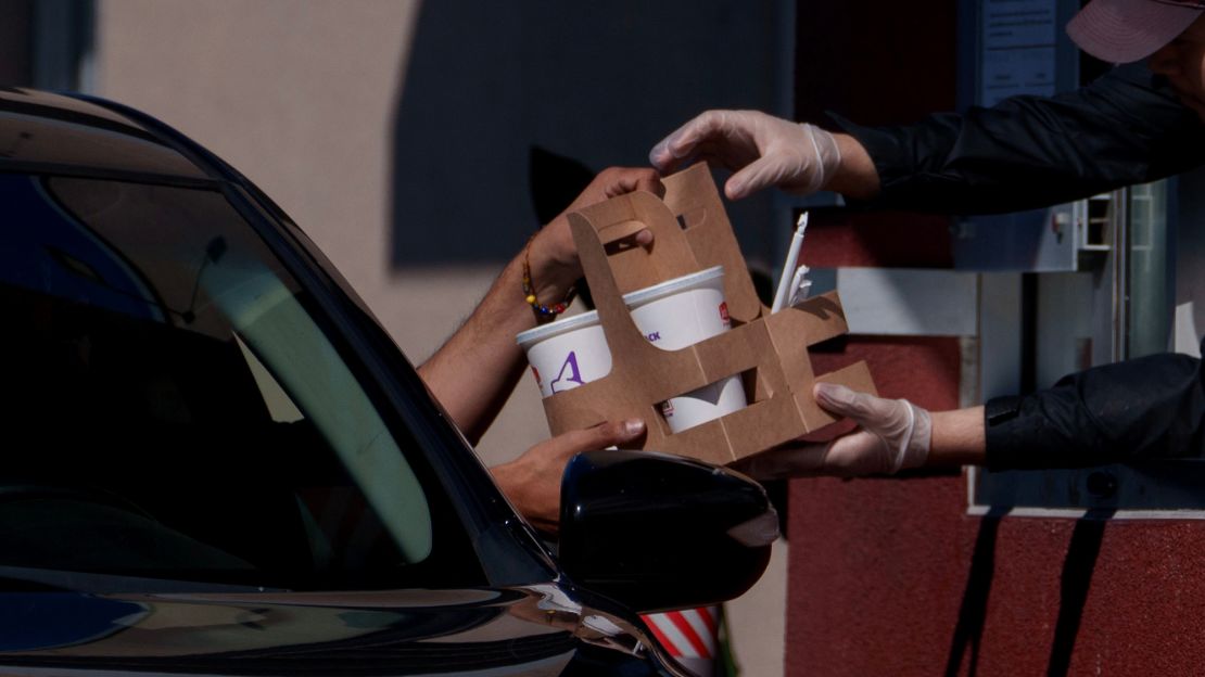 An employee hands items to a customer at the drive-thru of a Jack in the Box restaurant in Los Angeles, California, US, on April 1, 2024. California's fast-food law, which went into effect in April 2024, raised the minimum wage for most fast-food workers from $16 per hour to $20.