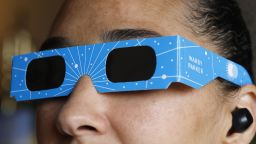 In this photo illustration, a woman models eclipse glasses from Warby Parker on April 01, 2024 in New York City. Warby Parker announced that it will be offering free glasses certified for safe viewing of the upcoming solar eclipse on April 8. People can visit any store to receive up to two pairs of solar eclipse glasses at no cost. The event will mark the last total solar eclipse that is visible from the United States until 2044.