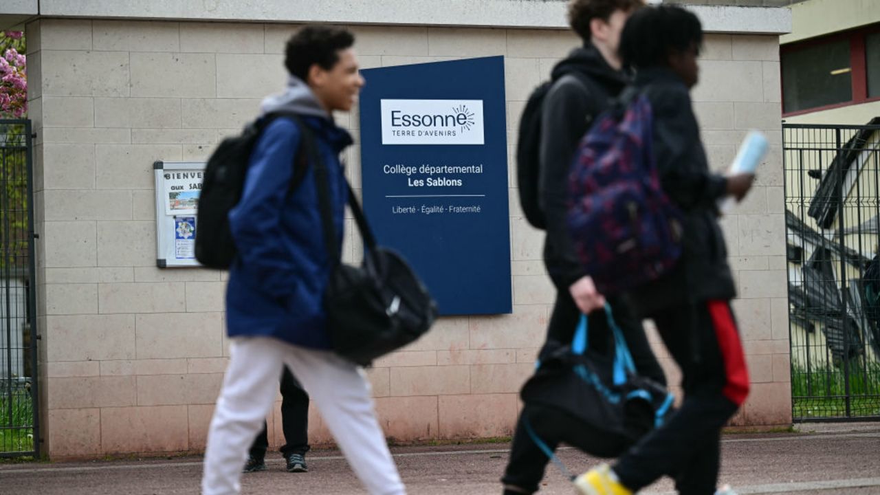 Middle schoolers walk by an indicative reading "Departmental middle school - Les Sablons" at the entrance of the school Les Sablons in Viry-Chatillon on April 5, 2024, a day after a teenage boy was assaulted and rushed to the hospital. A 15-year-old teenager has been badly beaten in a town south of Paris and rushed to hospital following a cardiac arrest, in the latest incident of school violence in , on April 4, 2024. (Photo by Miguel MEDINA / AFP) (Photo by MIGUEL MEDINA/AFP via Getty Images)