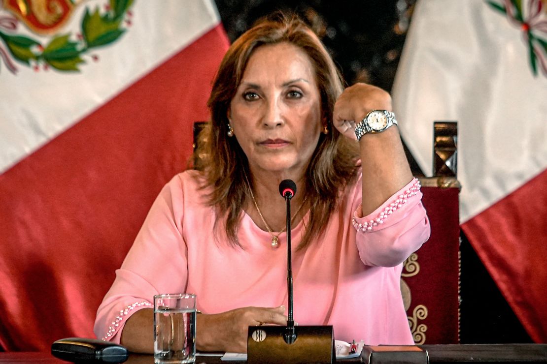 Peru's President Dina Boluarte shows her watch to a press conference after making a statement to the prosecutor's office following questioning over her Rolexes, in Lima, on April 5, 2024.