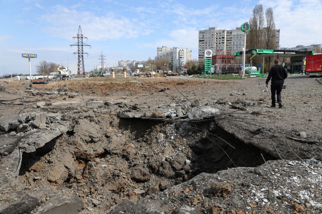 A man walks past a crater after Russian missile strikes on Kharkiv, Ukraine, April 6, 2024.