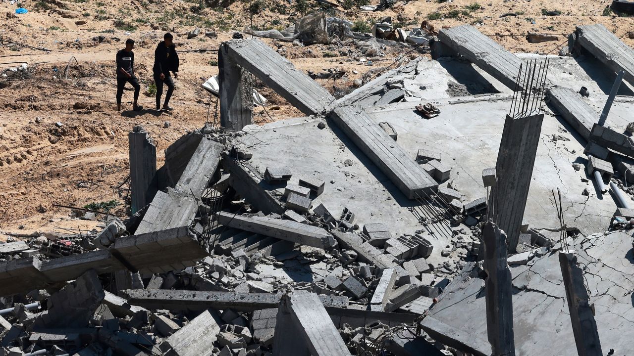 Men walk past a destroyed building in Khan Yunis on April 7, 2024, after Israel pulled its ground forces out of the southern Gaza Strip. Israel pulled all its troops out of southern Gaza on April 7, including from the city of Khan Yunis, the military and Israeli media said, after months of fierce fighting with Hamas militants left the area devastated.