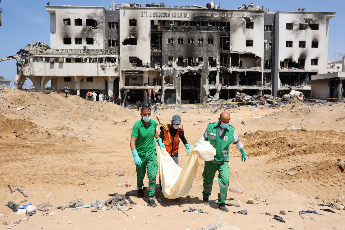 Palestinian forensic and civil defense workers recover human remains at the grounds of Al-Shifa, Gaza's largest hospital, which was reduced to rubble by a two-week Israeli raid, on April 8, 2024.