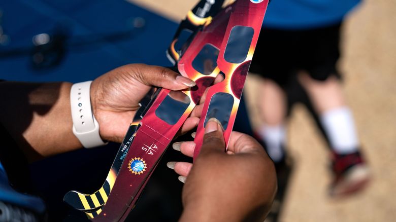 WASHINGTON, DC - APRIL 8:Volunteers hand out eclipse glasses as people gather on the National Mall to view the partial solar eclipse on April 8, 2024 in Washington, DC. People have traveled to areas across North America that are in the "path of totality" in order to experience the eclipse today, with the next total solar eclipse that can be seen from a large part of North America won't happen until 2044. (Photo by Kent Nishimura/Getty Images)