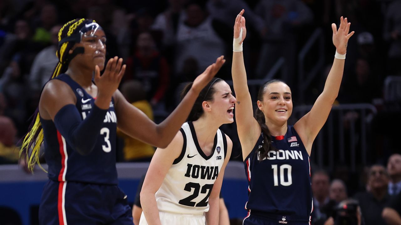 CLEVELAND, OHIO - APRIL 05: Caitlin Clark #22 of the Iowa Hawkeyes celebrates as Nika Muhl #10 and Aaliyah Edwards #3 of the UConn Huskies react after a foul called against UConn in the second half during the NCAA Women's Basketball Tournament Final Four semifinal game at Rocket Mortgage Fieldhouse on April 05, 2024 in Cleveland, Ohio. (Photo by Steph Chambers/Getty Images)