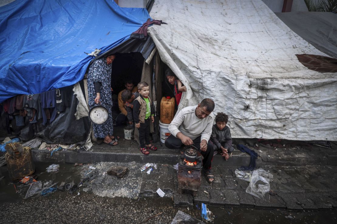 A displaced man makes tea outside his tent on Wednesday. Israel's war in Gaza has displaced most of the enclave's population.