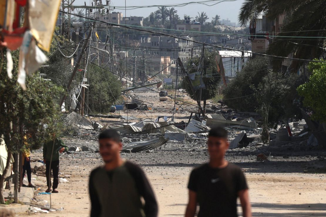 People walk among the ruins of buildings destroyed by an Israeli strike on Nuseirat refugee camp.