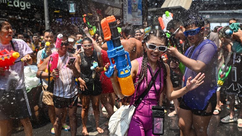 TOPSHOT - Revellers take part in mass water fights on the first day of Songkran, or Thai New Year, on Silom Road in Bangkok on April 13, 2024. (Photo by Lillian SUWANRUMPHA / AFP) (Photo by LILLIAN SUWANRUMPHA/AFP via Getty Images)