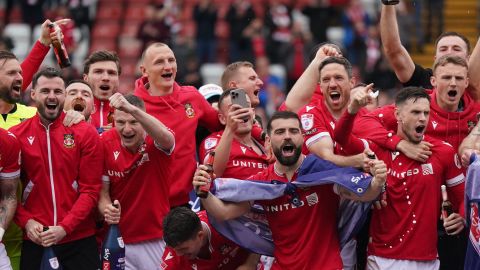 Wrexham players on the pitch celebrating promotion to League One after the final whistle of the Sky Bet League Two match at the SToK Cae Ras, Wrexham. Picture date: Saturday April 13, 2024. (Photo by Jacob King/PA Images via Getty Images)