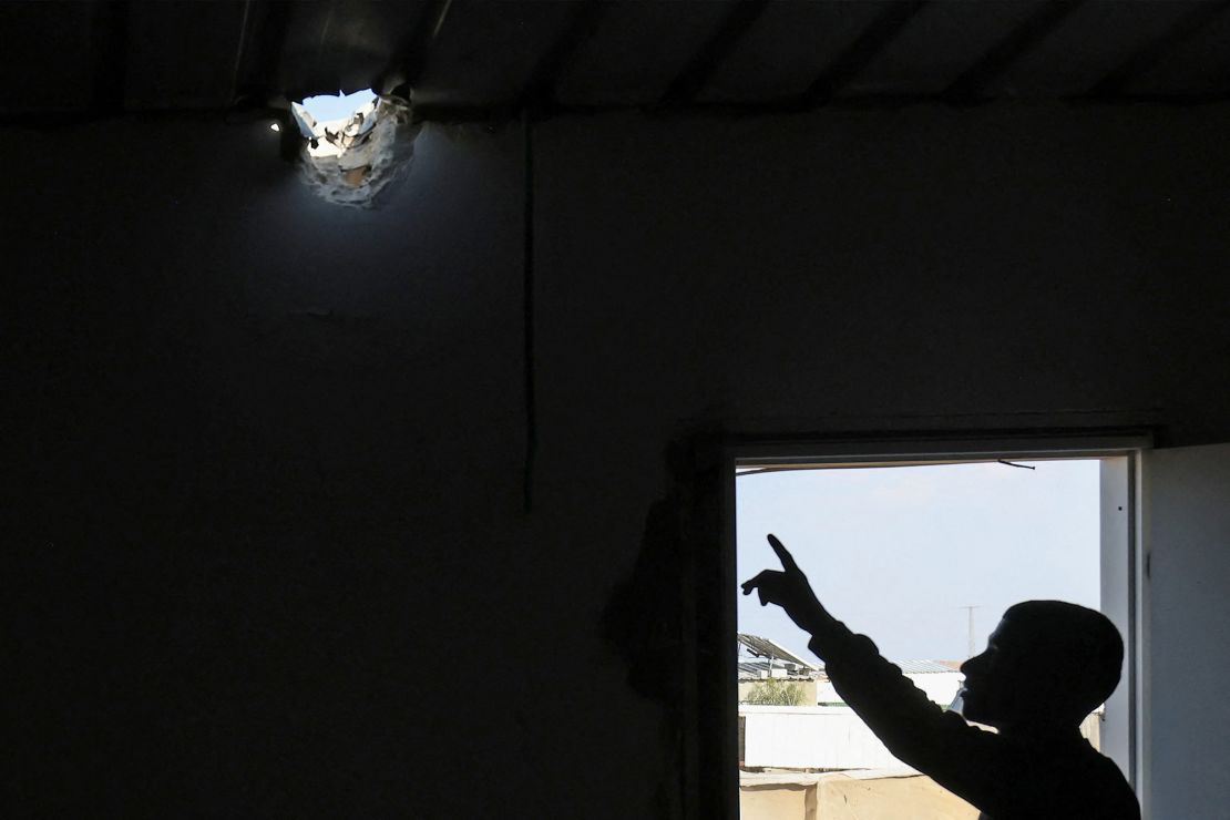 A man points to a hole in the roof of a building caused by a projectile that injured seven-year-old Bedouin girl Amina in her unrecognized village, in the southern Negev desert, in Israel on April 14.