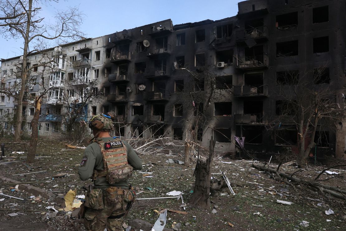 A Ukrainian police officer walks past a destroyed residential building, following artillery and air raids in the village of Ocheretyne, near the town of Avdiivka, in the Donetsk region, April 15, 2024.