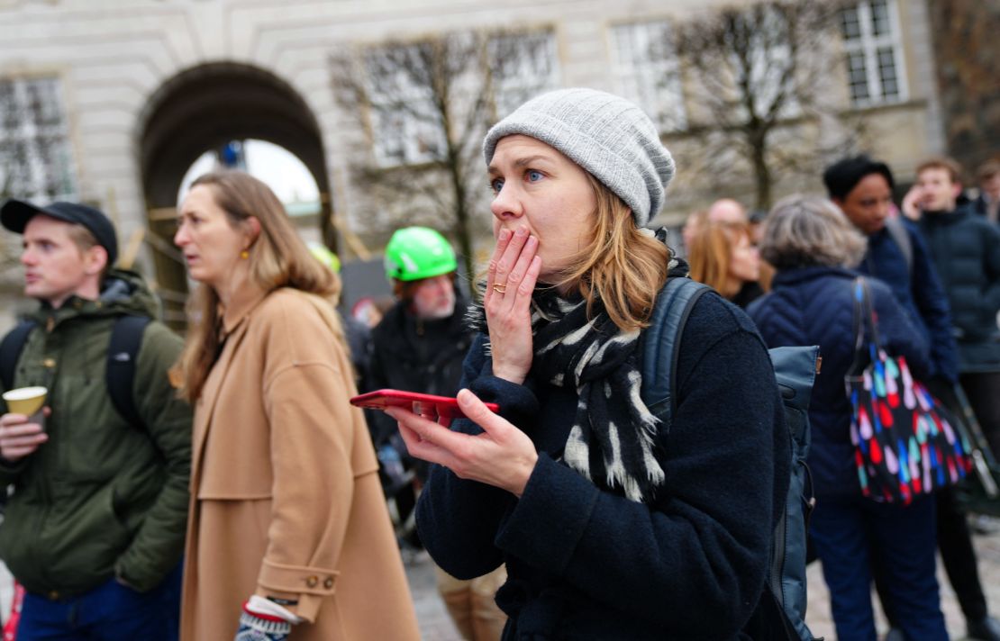 Shocked onlookers watch as the fire engulfs the historic building in central Copenhagen. 