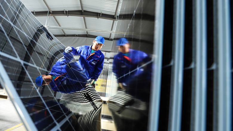 ZHANGYE, CHINA - APRIL 16, 2024 - Workers check photovoltaic panels before packing at the New Material 800MW high-efficiency photovoltaic module production line in Zhangye city, Gansu province, China, April 16, 2024.