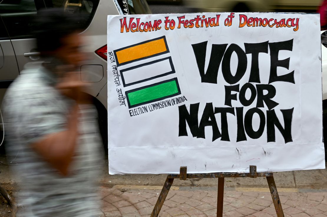 A pedestrian walks past an election painting in Mumbai on April 17, 2024.