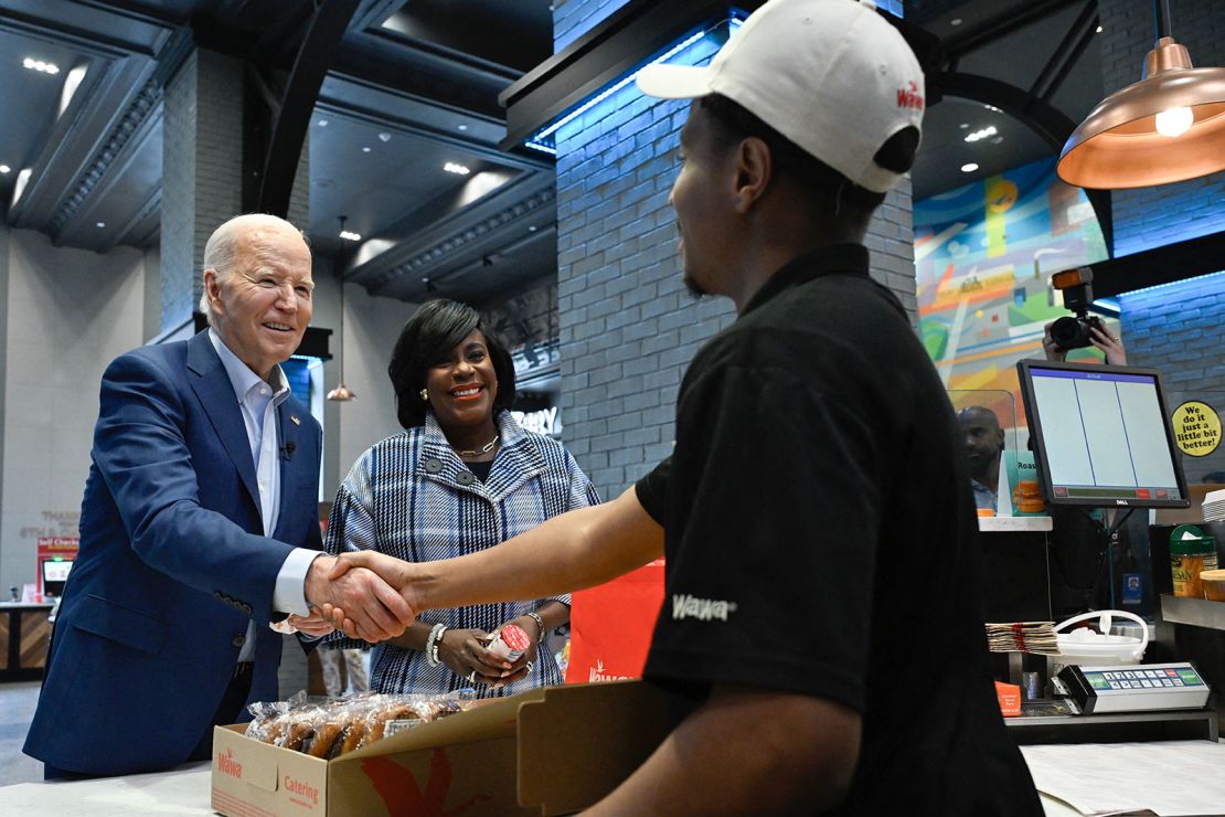 President Joe Biden shakes hands with an employee after ordering sandwiches at a Wawa store in Philadelphia on April 18, 2024.
