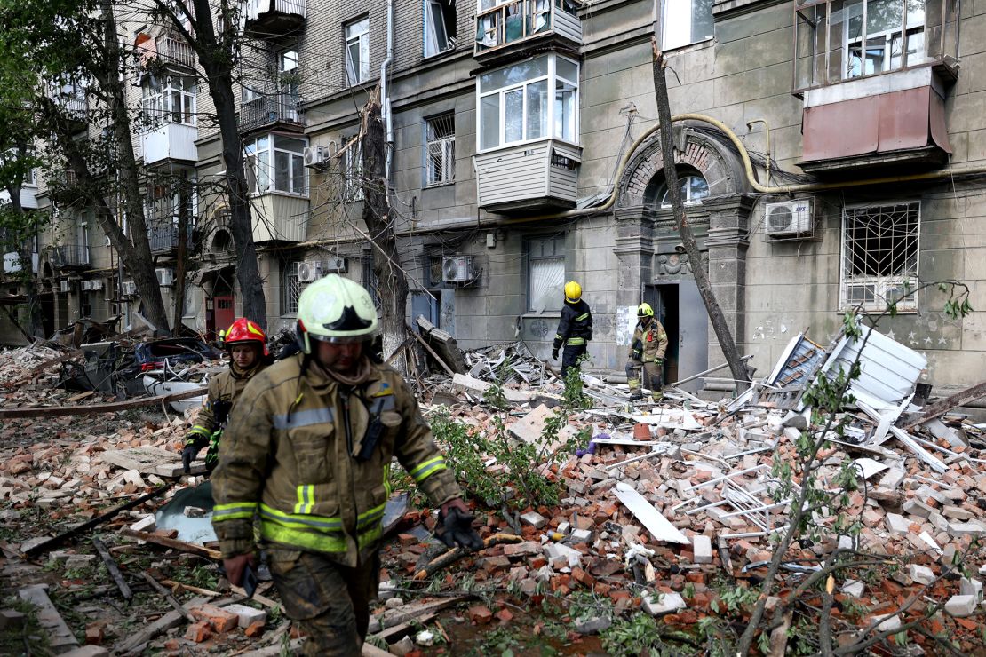 Ukrainian rescuers work in the courtyard of a damaged residential building in Dnipro, April 19, 2024.