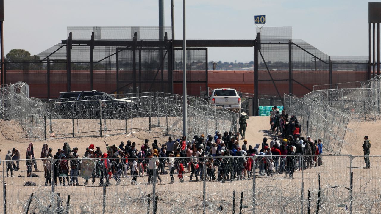 Migrants line up to be transferred by US Border Patrol after having crossed the Bravo River in El Paso, Texas, as seen from Ciudad Juarez, Chihuahua State, Mexico, on April 18, 2024. (Photo by HERIKA MARTINEZ / AFP) (Photo by HERIKA MARTINEZ/AFP via Getty Images)