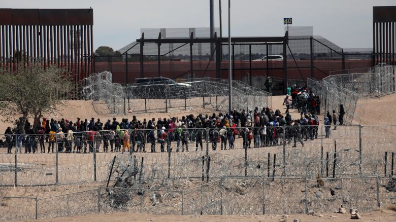 Migrants line up to be transferred by US Border Patrol after having crossed the Bravo River in El Paso, Texas, as seen from Ciudad Juarez, Chihuahua State, Mexico, on April 18, 2024.