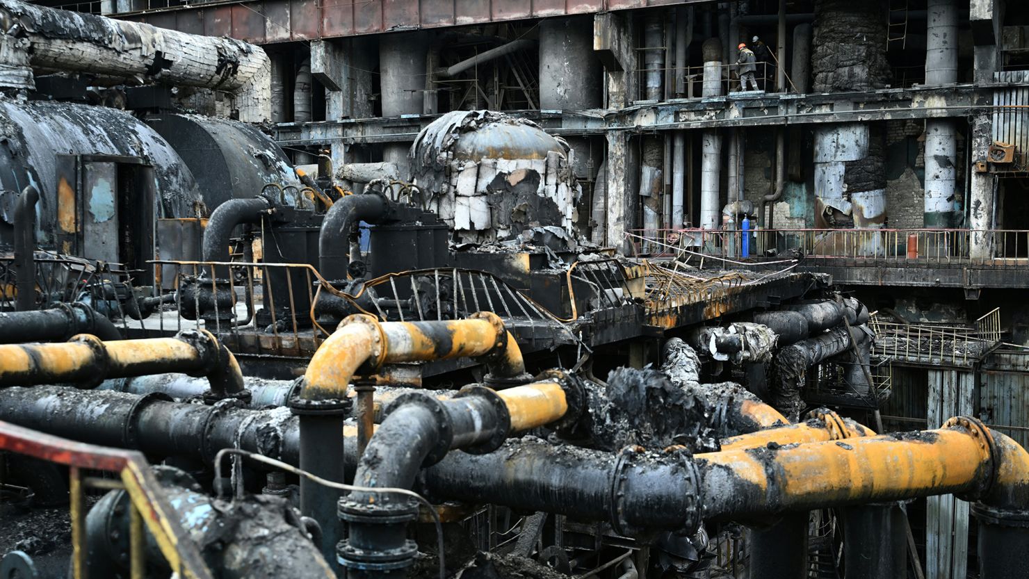 Workers remove debris in a turbine hall full of scorched equipment at a power plant in Ukraine in April 2024.