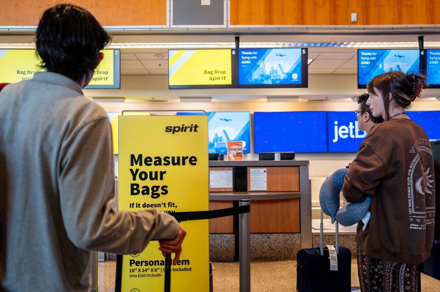 Customers wait in line to drop baggage off at a Spirit Airlines check-in counter in Austin, Texas. A federal judge blocked a proposed deal to have JetBlue buy Spirit Airlines in early 2024, saying it would hurt consumers by raising air fares.