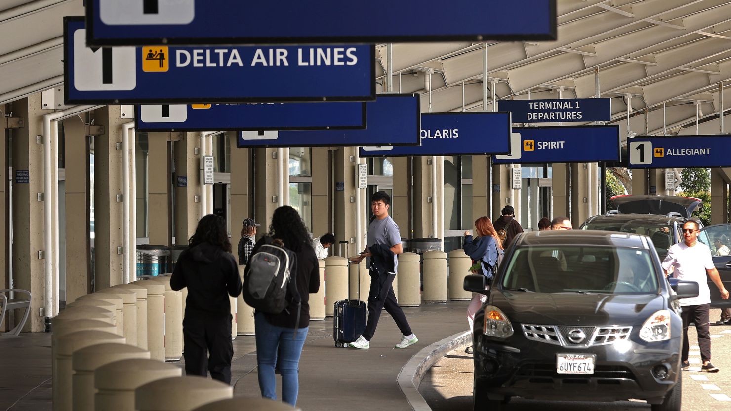 Travelers walk towards Terminal 1 at Oakland International Airport on April 12, 2024, in Oakland, California.